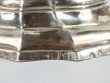 a silver plate with a bird on top of it