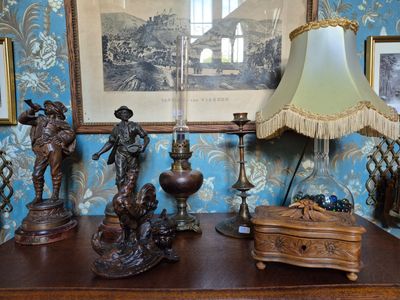 une table avec une lampe et un tableau accroché au mur derrière elle