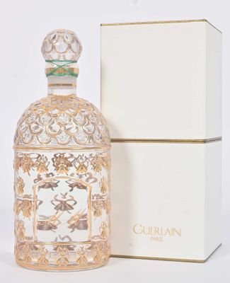 l'image d'un flacon de parfum posé à côté d'une boîte