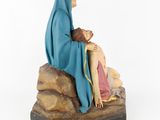 the statue of jesus is sitting on a rock next to a woman