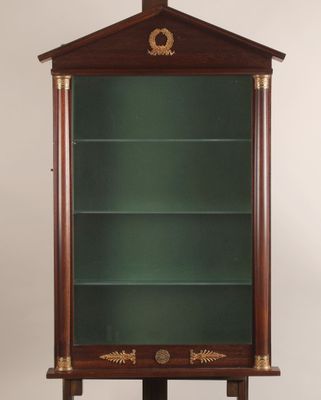 une vitrine ancienne en bois, dotée d'étagères en verre et de garnitures en laiton