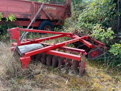 un tracteur rouge assis dans l'herbe