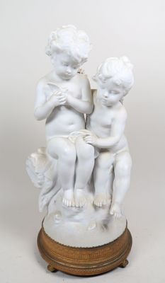 une statue représentant deux enfants assis sur une table