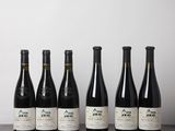 six bouteilles de vin alignées sur une table devant un mur blanc