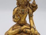 a gold statue of a person sitting on top of a table