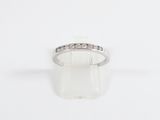 a close up of a diamond ring on a white surface