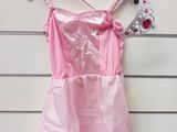 a pink dress hanging on a wall with a crown on it