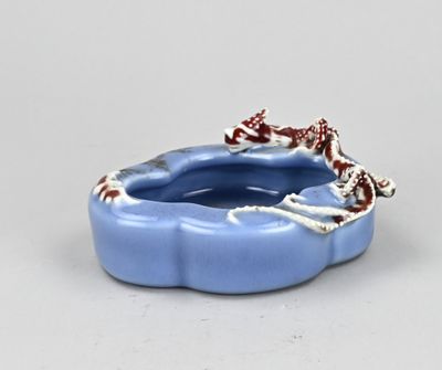 un petit bol bleu orné d'un motif rouge et blanc