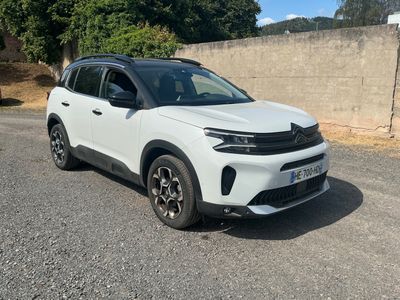 un SUV blanc garé sur un parking près d'un mur