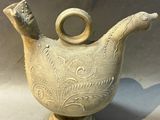 a white vase that has a handle on it
