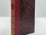 a red and black book sitting on top of a white table