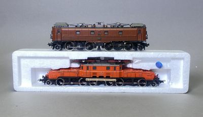 deux petits trains exposés sur une surface blanche