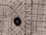 the jacket is made of white and black tweed with a black button