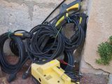 a yellow and black hoses and a yellow and black machine on the ground next to a brick wall
