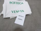 a white towel with green writing on it next to a bottle of wine
