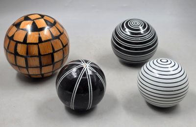 trois balles rayées de noir et blanc posées les unes à côté des autres sur une table