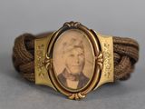 un gros plan d'un bracelet sur lequel figure la photo d'un homme