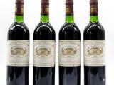 three bottles of wine are lined up on a white surface