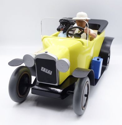a yellow toy car with a man in a hat driving it