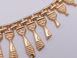 a gold necklace with a bunch of spoons hanging from it