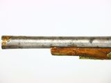 a close up of a gun with a wooden barrel