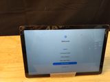 laptop computer sitting on top of a wooden table with a black background