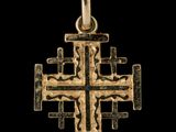 une image représentant un pendentif en forme de croix en or sur fond noir