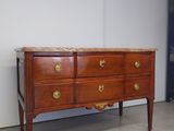 a wooden chest of drawers in a room with a white wall