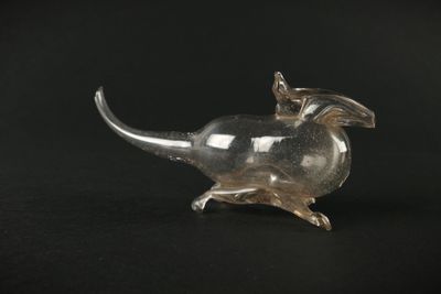 une image représentant une figurine de souris en verre sur fond noir