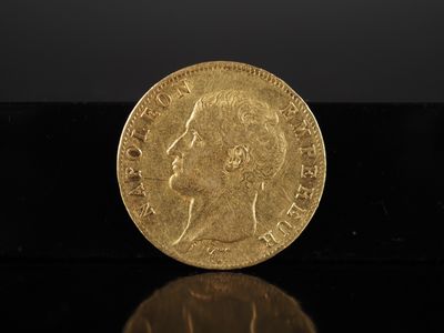 gros plan d'une pièce d'or sur une surface noire