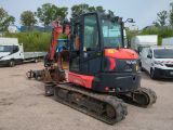 a picture of a small excavator parked in a parking lot