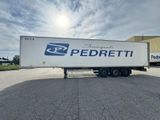 La semi-remorque est garée sur le parking, près d'un bâtiment.