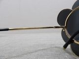a pair of black and gold sunglasses sitting on a white surface