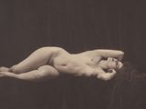 une vieille photo en noir et blanc représentant une femme nue allongée sur un lit