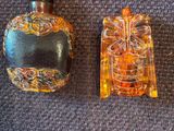 deux petites bouteilles en verre posées l'une à côté de l'autre sur un tapis