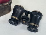 a pair of binoculars sitting on a table next to a bag