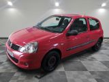 la petite voiture rouge est garée dans le garage sur un sol en damier