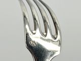 a close up of a fork on a table with a white background