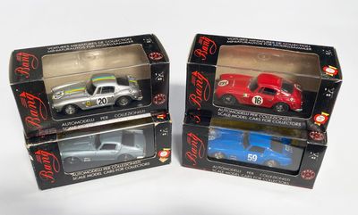 trois petites voitures dans leurs boîtes, posées sur une surface blanche