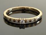 a close up of a diamond ring on a reflective surface