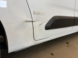 a close up of a white car with a denting on the side of it
