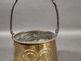 an old brass pot with a handle sitting on a table