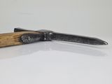 a knife with a wooden handle on a white surface