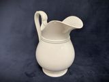a white pitcher that is sitting on a table