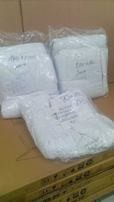 trois sacs de serviettes blanches posés sur une boîte en carton