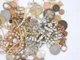 a pile of assorted jewelry on a white surface