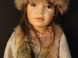 a doll that is wearing a fur hat and a scarf