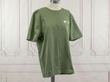 the green t - shirt is on a mannequin stand in front of a white wall