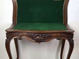 an old wooden bench with a green cushion on top of it