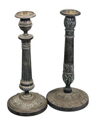 paire de bougeoirs anciens, noirs et blancs, ornés de motifs élaborés